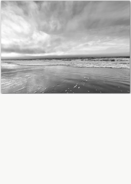 Poster in Schwarz-Weiß mit einem dramatischen Himmel über dem Strand