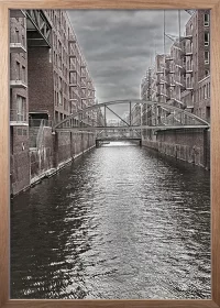 Poster mit Kanal in der Speicherstadt Hamburg in einer monochromen Interpretation mit einem Rahmen in Eiche Poster mit Kanal in der Speicherstadt Hamburg in einer monochromen Interpretation mit einem Rahmen in Eiche