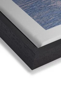 Wandbild mit Sonnenuntergang am Meer in warmer Farbstimmung auf Leinwand mit einem schwarzen Rahmen