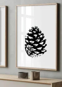 Poster mit Illustration eines Pinienzapfens in schwarz-weiß über einer Kommode hängend