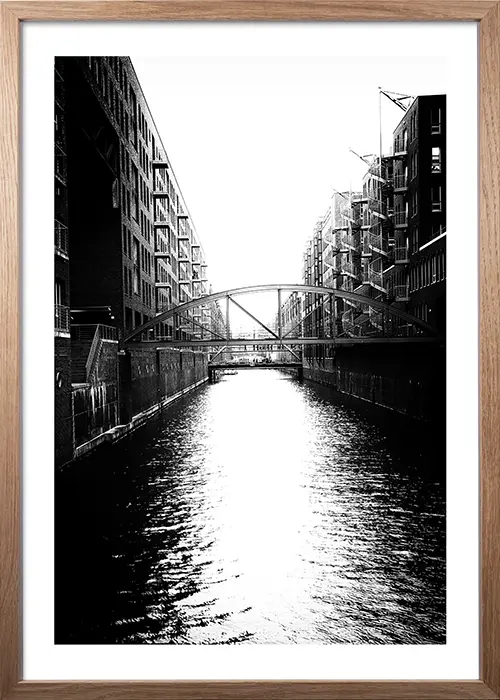 Poster der Hamburger Speicherstadt mit Kanal in schwarz-weiß mit einem Rahmen aus Eiche