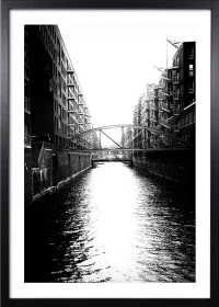 Poster der Hamburger Speicherstadt mit Kanal in schwarz-weiß mit einem schwarzen Rahmen Poster der Hamburger Speicherstadt mit Kanal in schwarz-weiß mit einem schwarzen Rahmen