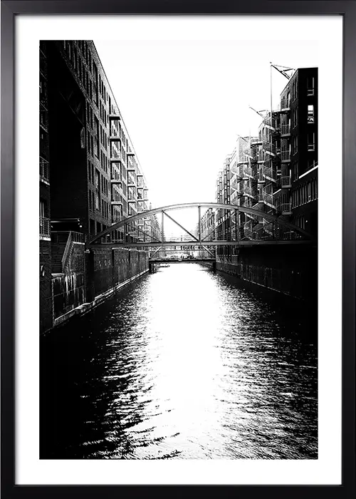 Poster der Hamburger Speicherstadt mit Kanal in schwarz-weiß mit einem schwarzen Rahmen Poster der Hamburger Speicherstadt mit Kanal in schwarz-weiß mit einem schwarzen Rahmen