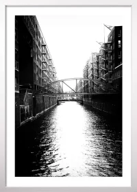 Poster der Hamburger Speicherstadt mit Kanal in schwarz-weiß mit einem weißen Rahmen Poster der Hamburger Speicherstadt mit Kanal in schwarz-weiß mit einem weißen Rahmen