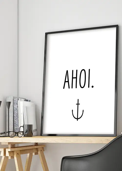 Poster mit Typografie "AHOI." und Anker in schwarz-weiß auf einem Tisch an die Wand gelehnt
