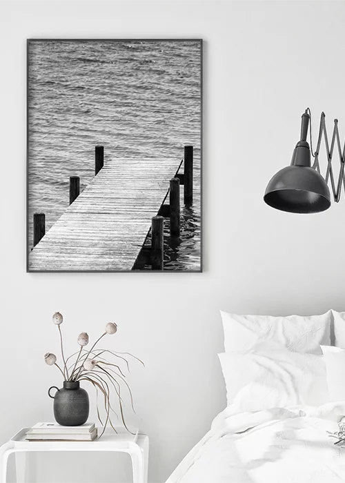 Poster mit Bootssteg auf einen See hinaus in schwarz-weiß im Schlafzimmer hängend