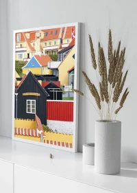 Poster mit bunten Häusern in Skagen, Dänemark, auf einem weißen Sideboard stehend