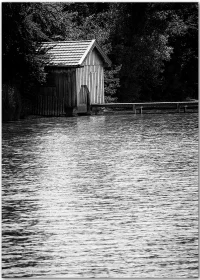 Poster mit einem alten Bootshaus an einem See in schwarz-weiß