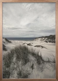 Poster mit Blick von einer Düne auf das Meer mit dramatischem Himmel in einem Eiche-Rahmen