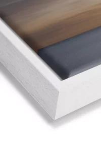 Wandbild mit einem Sonnenkegel auf dem Meer auf Leinwand mit einem weißen Rahmen