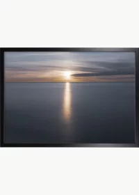 Poster mit einem Sonnenkegel auf dem Meer in einem schwarzen Rahmen