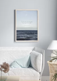 Poster mit Meer und einem Zitat von Christoph Columbus über einem Sofa hängend