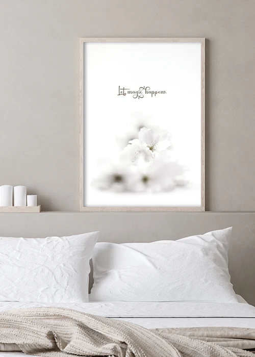 Poster mit Motivationsspruch und weißen Blumen über einem Bett