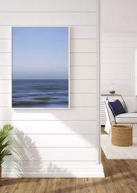 Poster mit abstrakter Darstellung von Meer und Himmel an einer weißen Holzwand hängend
