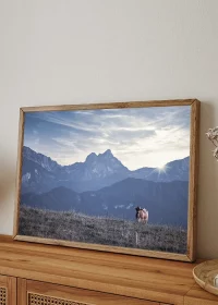 Poster mit einer "einsamen" Kuh auf einer Wiese in den Alpen auf einem Sideboard