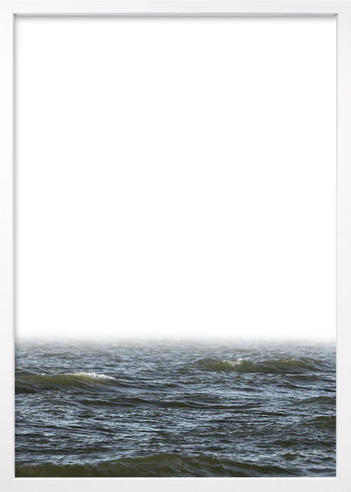 In weißem Holz gerahmtes Poster mit nebligem Himmel über dem Meer.