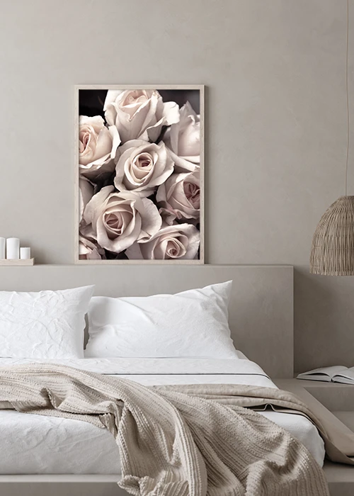Poster mit einem Bouquet aus rosa Rosen über einem Bett hängend