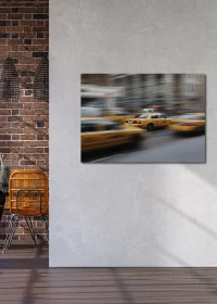 Poster in verwischter Optik mit gelben New Yorker Taxis an einer grauen Wand hängend