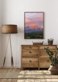 Poster mit farbenprächtigem Sonnenuntergang über dem Karwendelgebirge über einer Holzkommode hängend