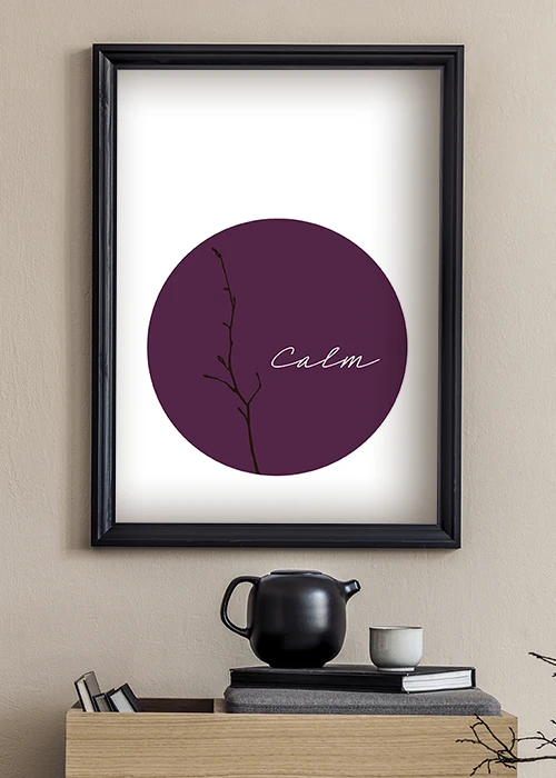Poster in minimalistischem Japandi-Style mit einem schwarzen Zweig und dem Wort Calm vor einem weinroten Kreis an einer Küchenwand