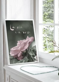 Poster mit einer rosa Rose auf dunkelgrünem Grund und inspirierendem Spruch in einer Fensterbank stehend