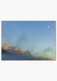 Poster mit Blick auf Berge im Sonnenaufgang und dem Mond an einem blauen Himmel