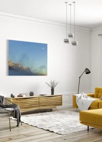 Poster mit Blick auf Berge im Sonnenaufgang und dem Mond an einem blauen Himmel an einer Wohnzimmerwand hängend