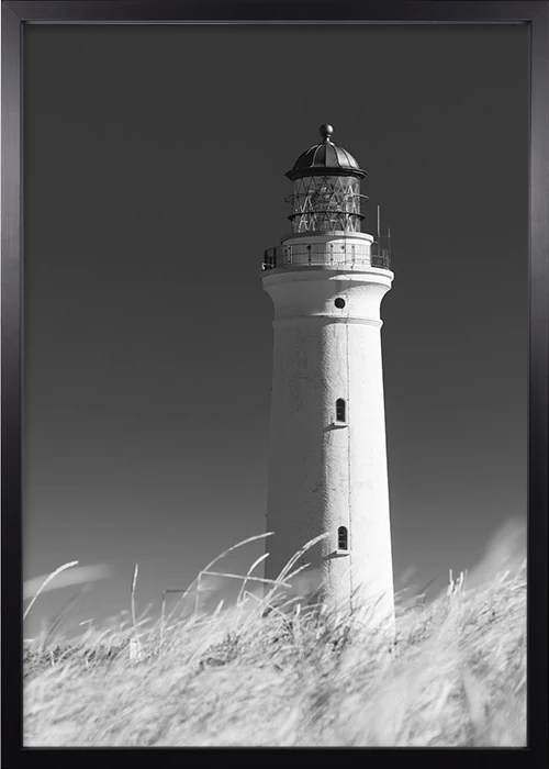 Poster mit einem Leuchtturm in Schwarz-Weiss in einem schwarzen Rahmen