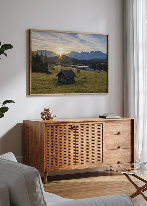 Poster über einem Sideboard mit einem Sonnenaufgang am Karwendel