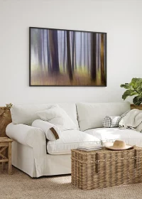 Hochwertiges Poster in schwarzem Rahmen mit mystischen Bäumen warmen Naturfarben, aufgehängt über einem Sofa