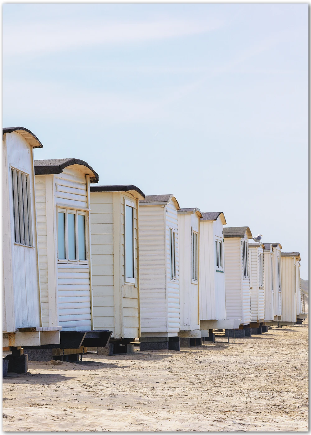 Poster mit Badehäusern am Strand.