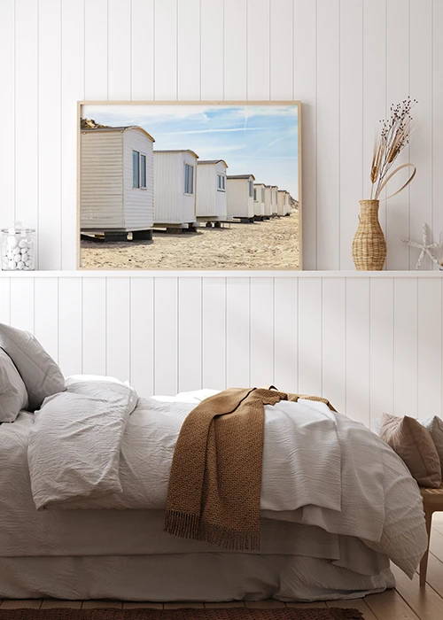 Inspiration – Wandbild mit weißen Badehäusern am Meer, aufgestellt in einem Schlafzimmer