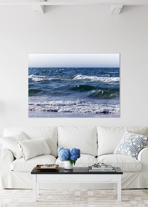 Inspiration – Wandbild AluDibond mit Wellen auf dem blauen Meer über einem weißen Sofa.